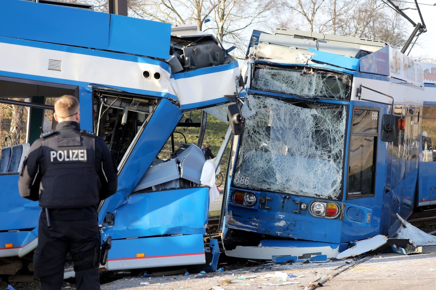 Nach einem Zusammenstoß von zwei Straßenbahnen in Rostock sichern Polizisten die Unfallstelle.