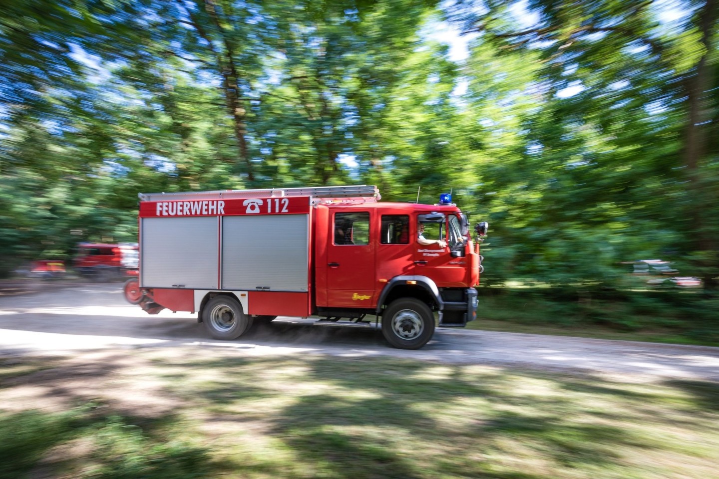 Ein Fahrzeug der Feuerwehr fährt in der Nähe des Einsatzortes: Die Einsatzkräfte scheinen den Waldbrand in der Lieberoser Heide nun im Griff zu haben.