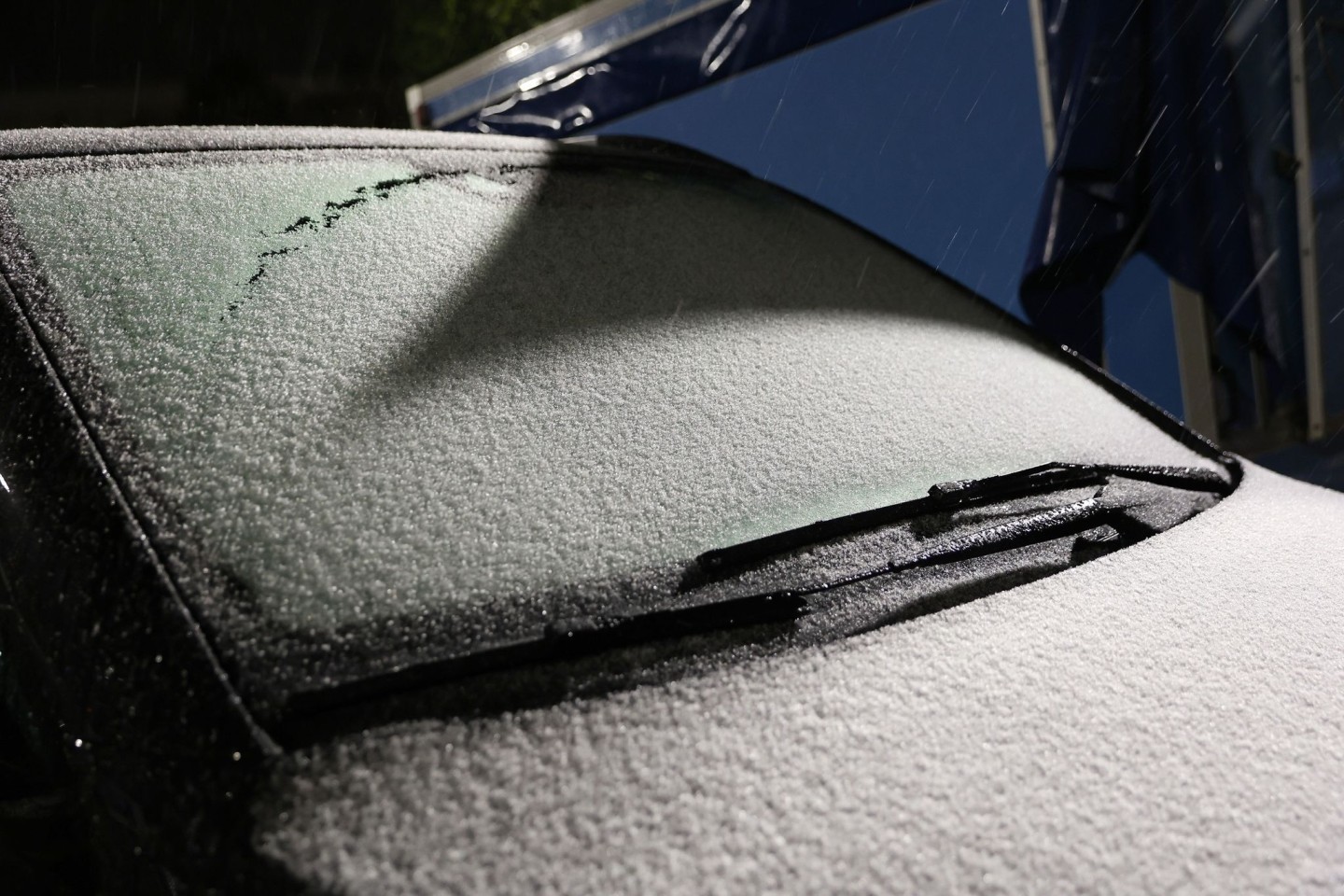Schnee liegt auf der Windschutzscheibe eines Autos am Flughafen Hamburg.