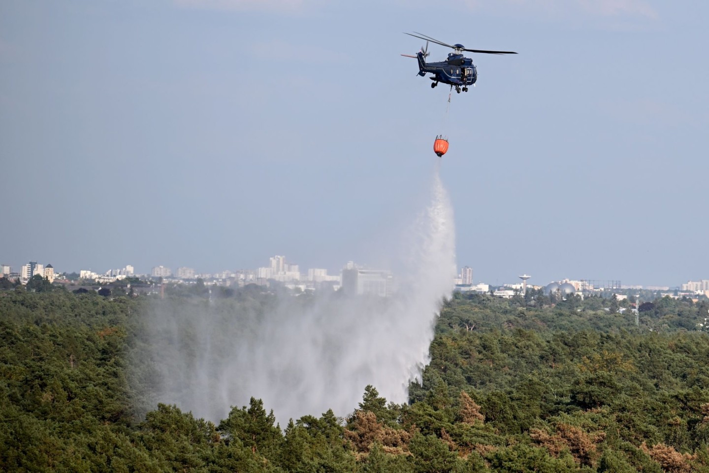 Löscharbeiten aus der Luft: Ein Hubschrauber der Bundespolizei wirft Wasser über der Brandstelle im Grunewald ab.