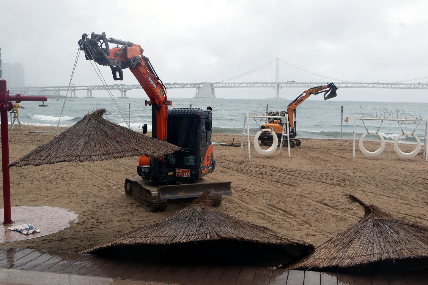 Vorbereitung auf Taifun «Hinnamnor»: Kran-Bagger bauen am Gwangalli-Strand in Südkorea Sonnenschirme ab.
