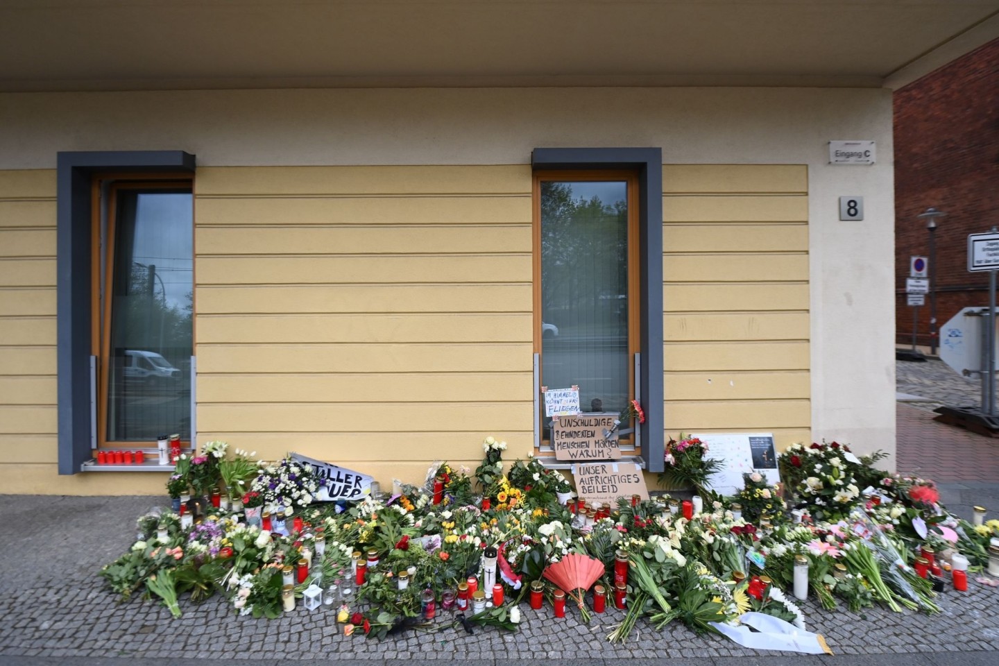 Blumen, Kerzen und Plakate erinnern vor dem Wohnheim in Potsdam an die getöteten Bewohner.