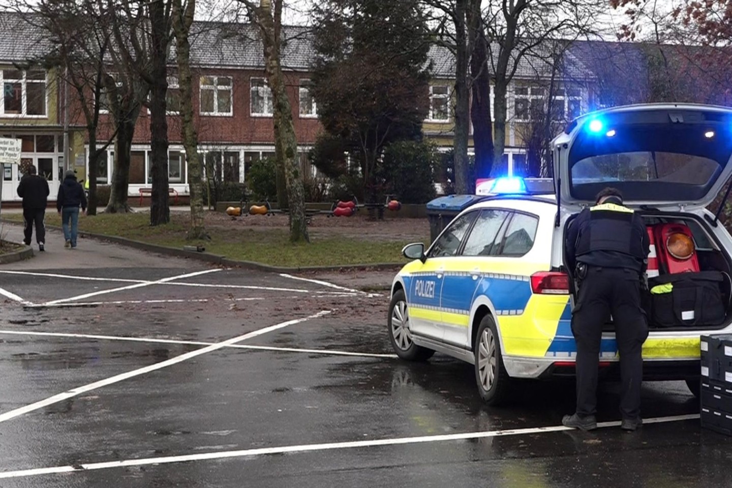 Ein Polizeiauto steht vor dem Gebäude einer Grund- und Hauptschule in Lüdingworth. Dort hat ein Mädchen ein anderes mit einem Messer schwer verletzt.