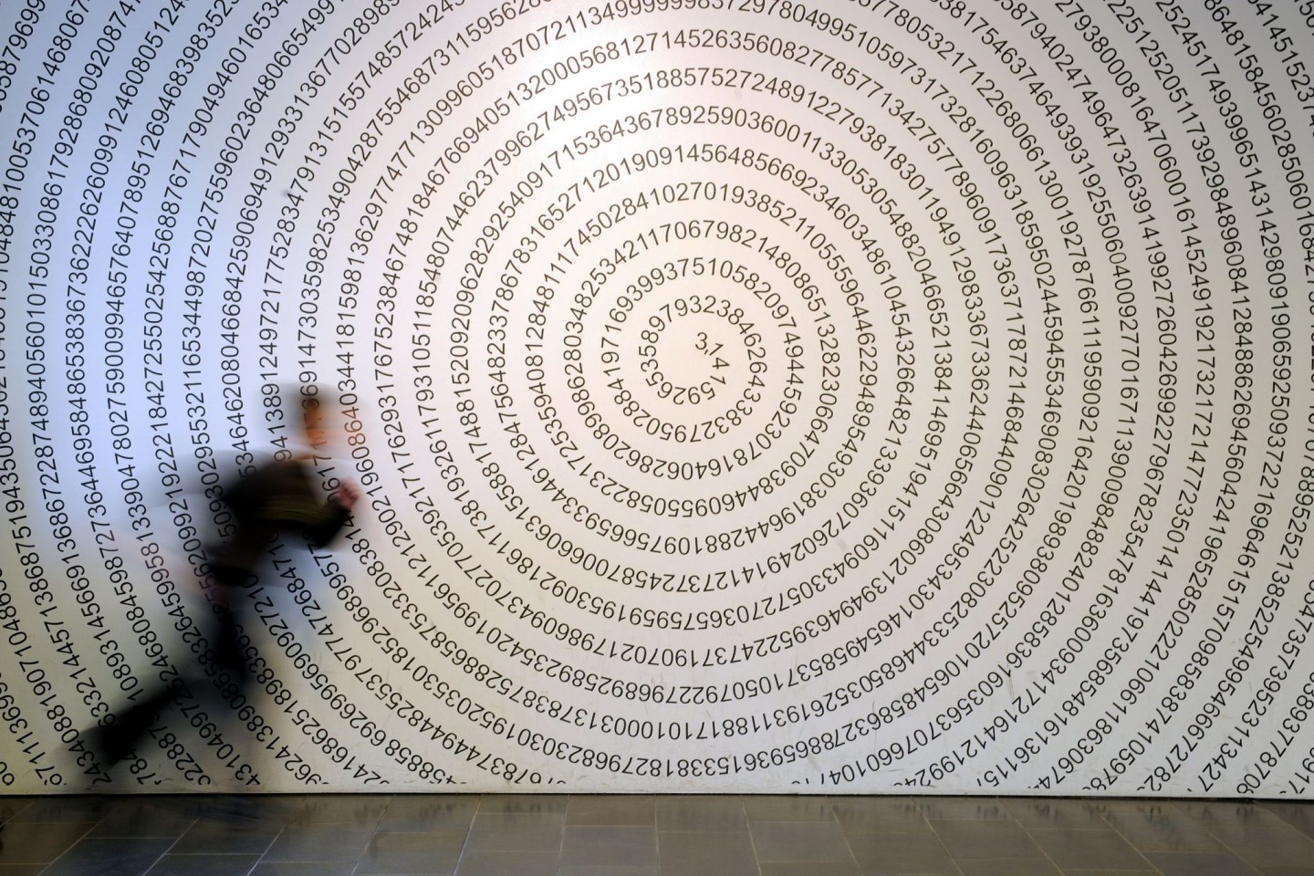 Ein Schulkind läuft im Gießener Mitmachmuseum «Mathematikum» an der Kreiszahl Pi vorbei.