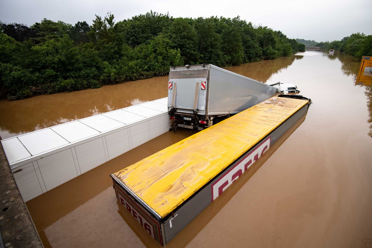 Drei Lastwagen stehen auf der überfluteten Bundesstraße 265 im tiefen Wasser und sind kaum mehr zu erkennen.