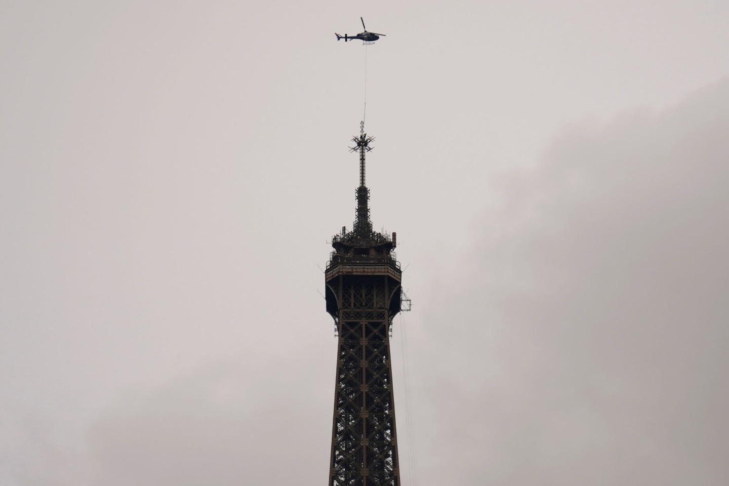 Ein Hubschrauber installiert die neue Antenne auf der Spitze des Eiffelturms.