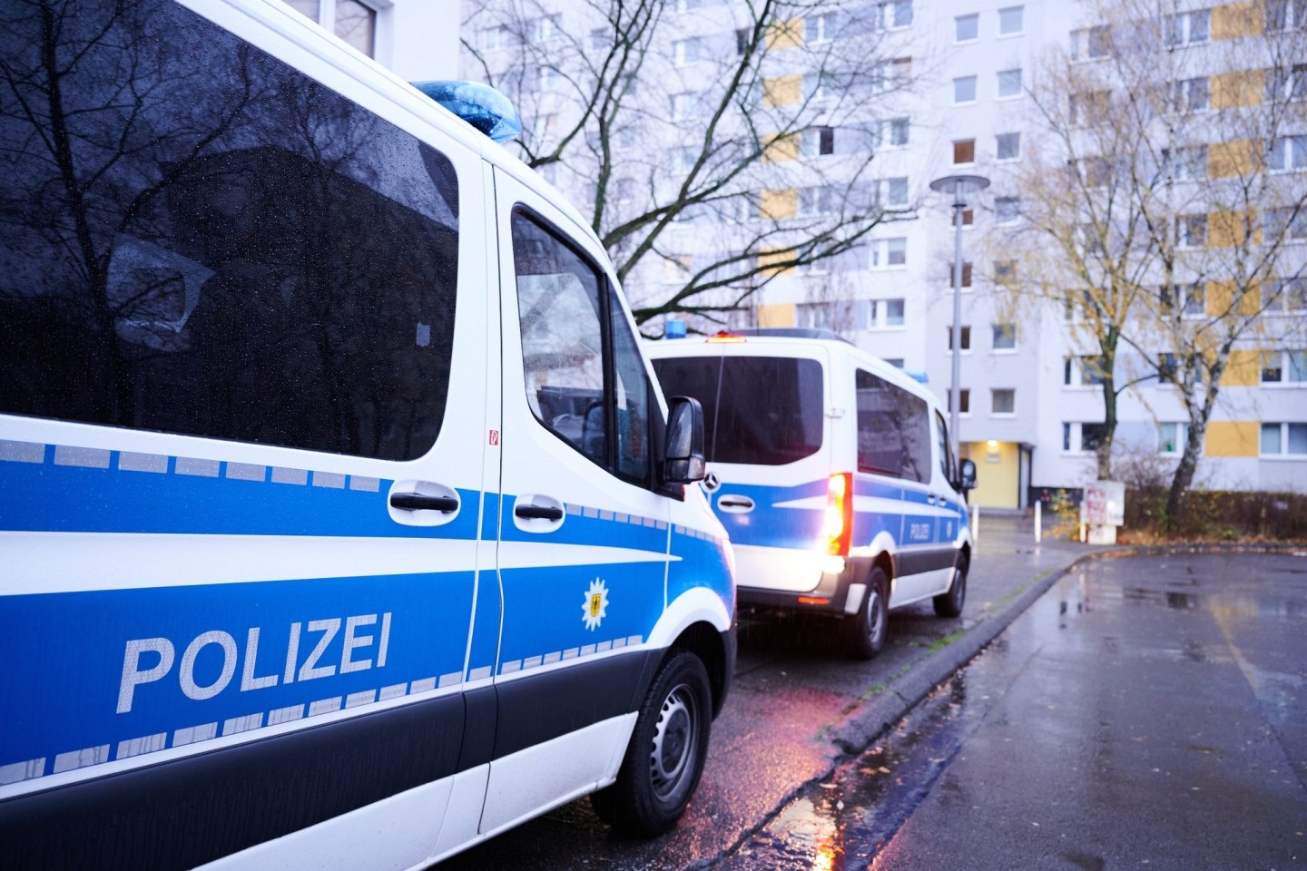 Fahrzeuge der Bundespolizei vor einem Wohnhaus in Berlin. Die Durchsuchung steht im Zusammenhang mit dem Verdacht auf Schleuserkriminalität.