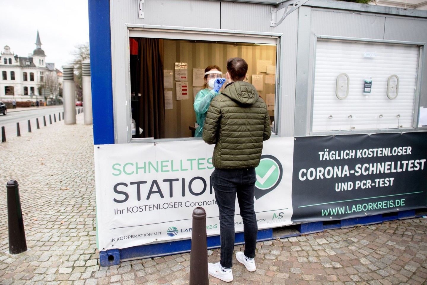 Eine Mitarbeiterin einer Teststation in der Oldenburger Innenstadt nimmt einen Abstrich von einem jungen Mann. (Archivbild)