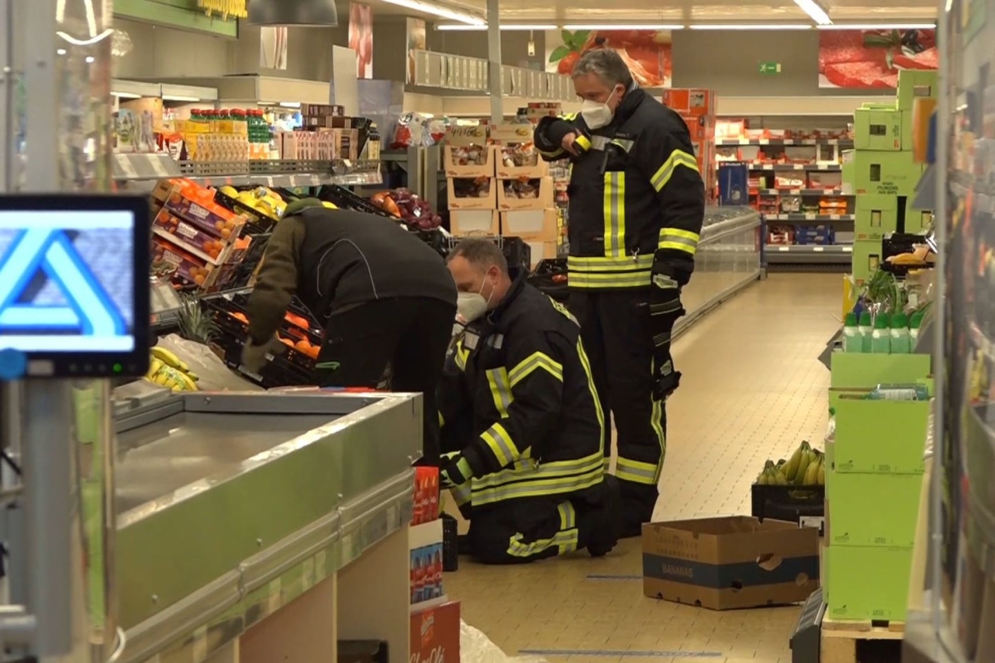 Einsatzkräfte der Polizei, Feuerwehr und ein Spinnenexperte suchen in den Obst- und Gemüseregalen des Supermarktes nach dem Tier.