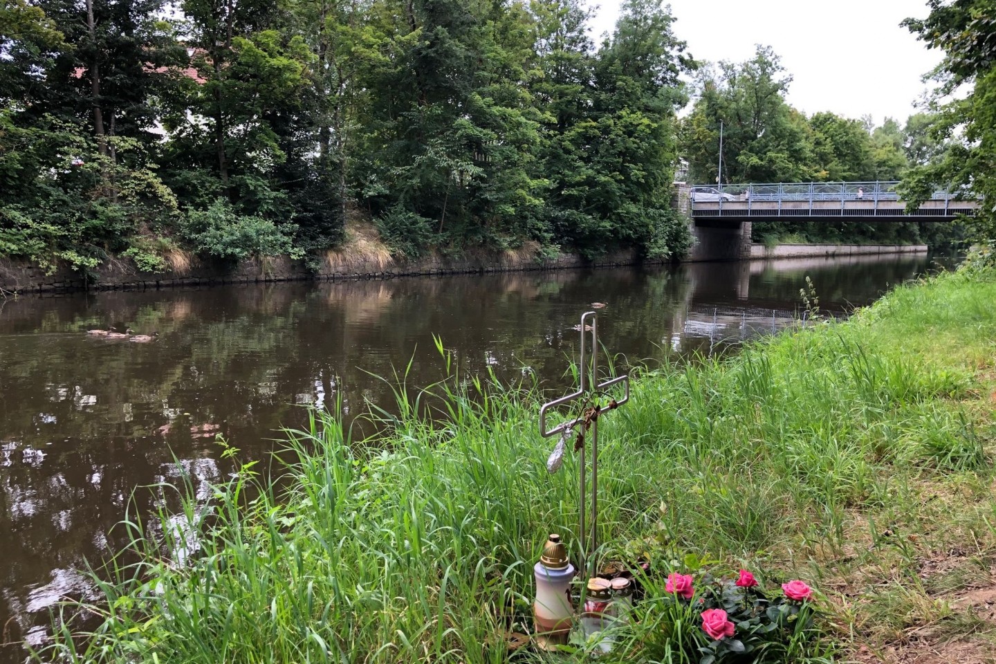 Ein Kreuz am Ufer des Flutkanals in Weiden erinnert an den Tod eines Mannes im September 2020.