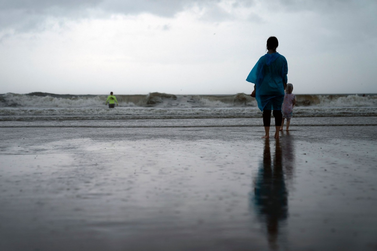 Kamila Struk (r) beobachtet ihren Vater Nickolas, der an einem gesperrten Strand in die Wellen watet, während der Tropensturm «Henri» über den US-Bundesstaat New York zieht.