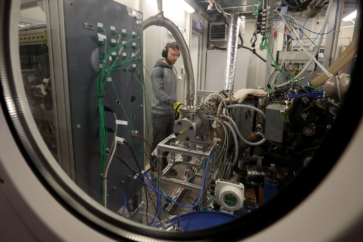 An einem Teststand in der Forschungshalle der Fakultät für Maschinenbau und Schiffstechnik der Universität Rostock kontrolliert der Doktorand Benedikt Gündling ein Verbrennungssystem, da...