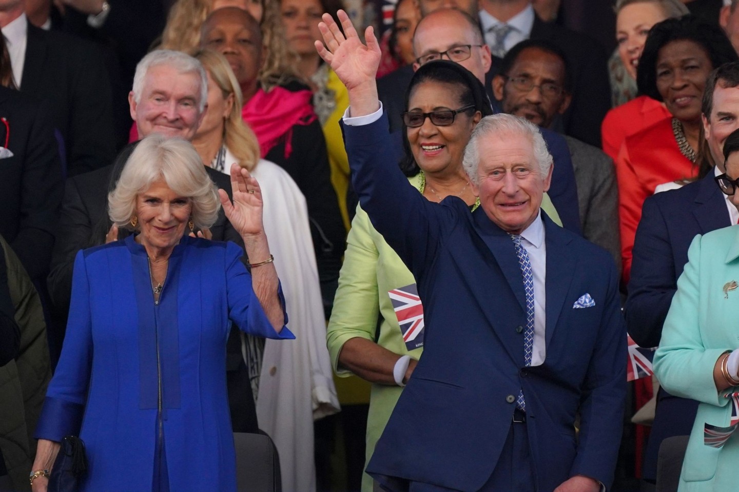 Der britische König Charles und Königin Camilla winken beim Konzert auf Schloss Windsor.